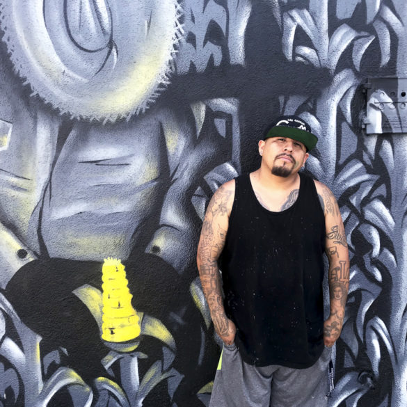 Graffiti artist Lesho poses for a photo in front of one of his murals at the Graff Lab in the Pico Union neighborhood of Los Angeles.