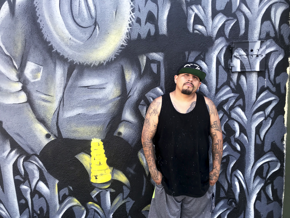 Graffiti artist Lesho poses for a photo in front of one of his murals at the Graff Lab in the Pico Union neighborhood of Los Angeles.