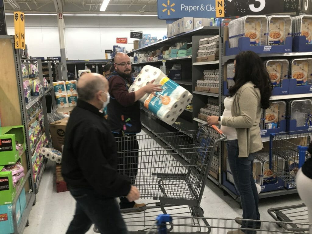 A Walmart manager loads up a cart for a customer.