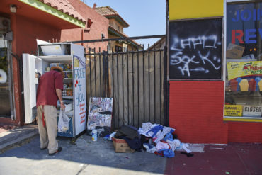 A man grabs some food from a community fridge.