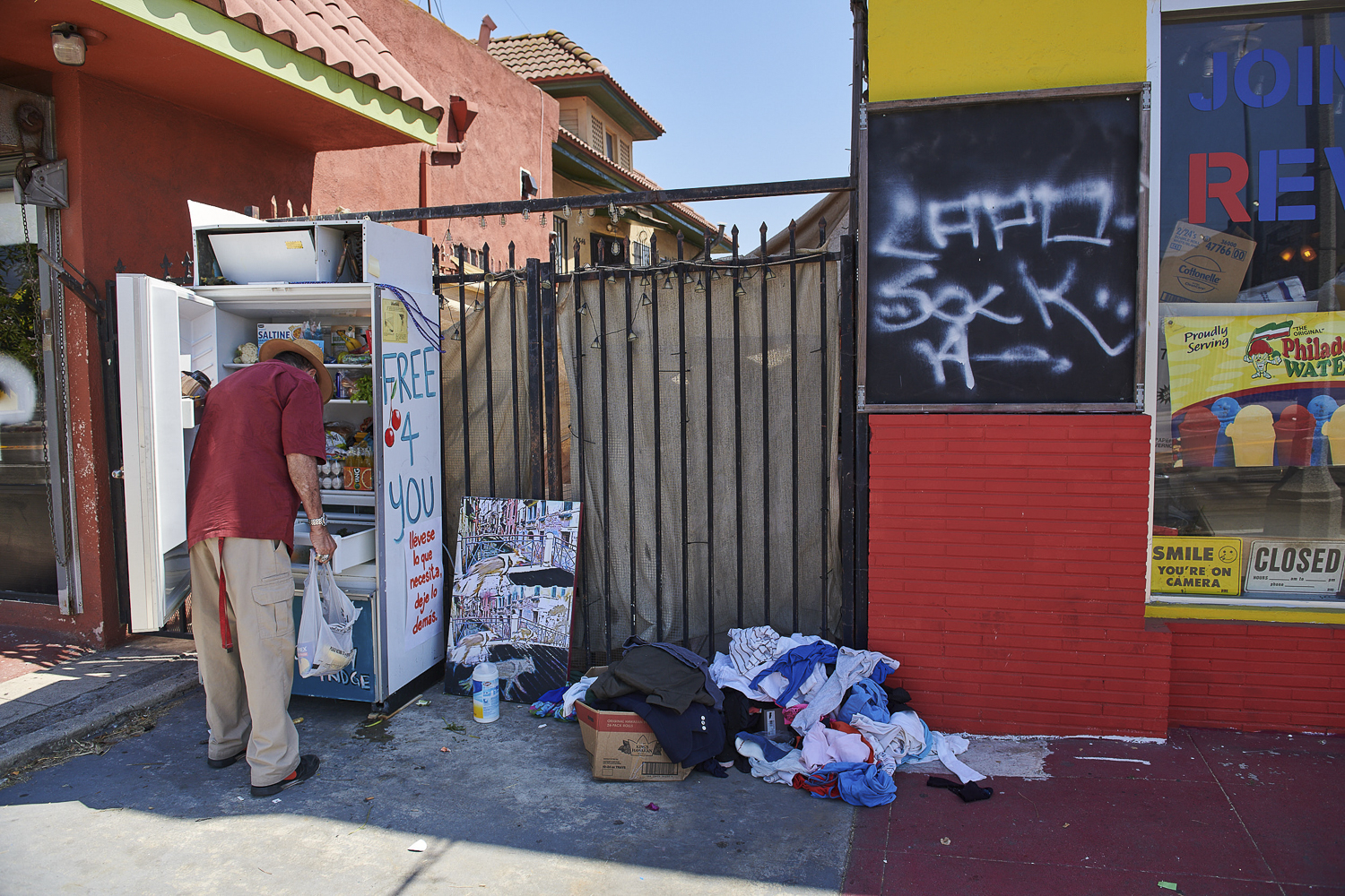 A man grabs some food from a community fridge.