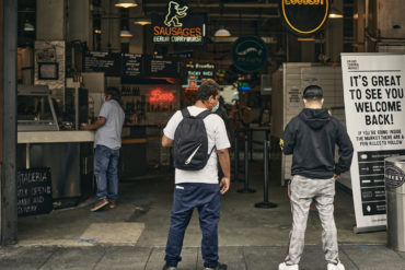 Customers wait outside Grand Central Market for their takeout orders.