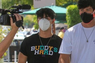 Bryce Hall and Blake Gray walking while wearing face masks, with a paparazzi cameraman visible in the corner.