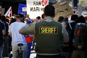 A Los Angeles Sheriff’s Department deputy watches a crowd at an anti-war protest in 2012.