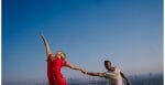 Two people dance against the backdrop of a blue sky and the L.A. skyline.