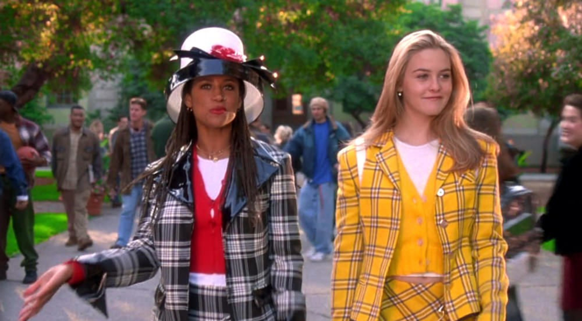 Two girls walk side-by-side down an outdoor campus quad, dressed in monochrome plaid preppy outfits.