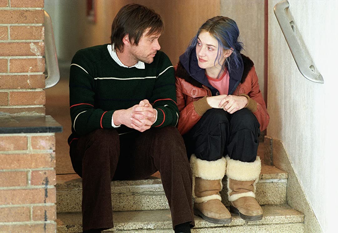 A man and a woman sit on a stoop, engaged in a deep conversation.