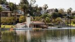 A daytime photo of Echo Park Lake, with hillside neighborhoods in the background.