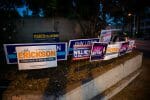 Campaign signs for the West Hollywood City Council race are crowded together near a polling place.